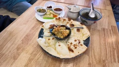 Burmese Style Naan Flatbread Served with Chickpea Curry on Wooden Table Stock Footage 345692014