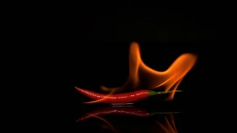 Burn Chili on black background slow motion Stock Footage