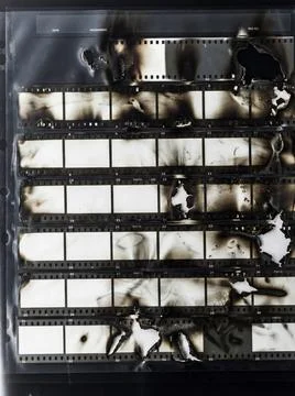 Burned and damaged empty 35mm black and white film strips. Stock Photos
