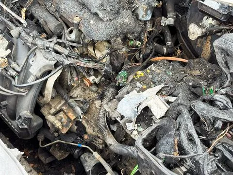 Burned car engine block and wiring with melted plastic covers, charred conn.. Stock Photos