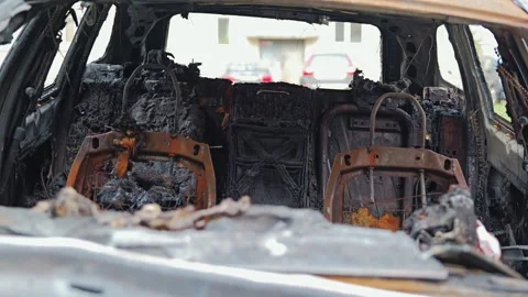 Burned car interior, charred seats and melted surfaces after fire in urban area Video stock 310538425