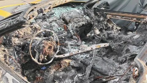 Burned car interior showing steering wheel and dashboard damage Vidéo 311025474