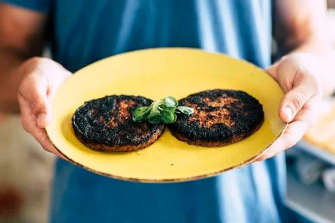 Burned cooked hamburger with chef mistake at home - concept of cook in the ki Fotos Stock