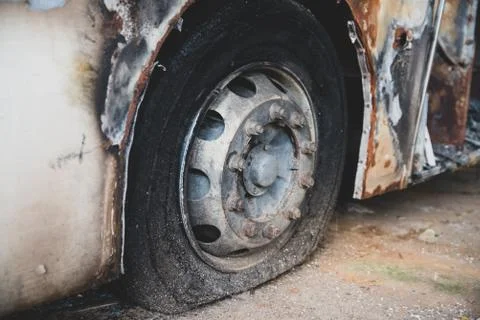 Burned down bus, view from outside, damaged walls and wheels 스톡 사진