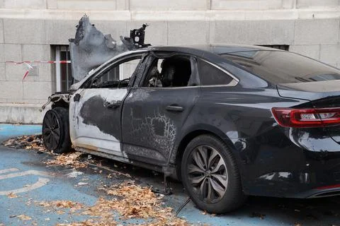 Burned expensive black car with mangled hood Stock Photos