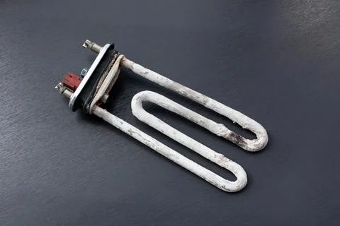 Burned heating element from a washing machine resting on a dark surface Stock-Fotos