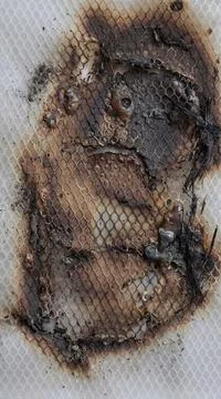 Burned Melted Plastic Texture with Charred Surface and Grid Pattern. Stock Photos