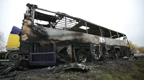 Burned-out passenger bus on the side of the road Stock Footage 42311912