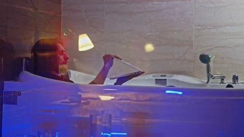 A burned-out worker tries to perform a task on his laptop while lying in the Stock Footage 252274013