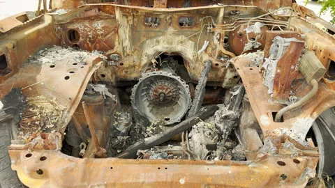 Burned rusted car chassis exposes severe devastation outdoors Stockbeeldmateriaal 336864312