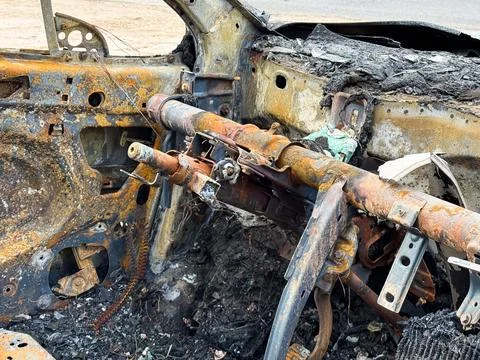 Burned steering column and dashboard frame from a car showing rusted metal .. Foto stock