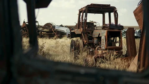 Burned tractor rusts in a junkyard Stock Footage 305308908