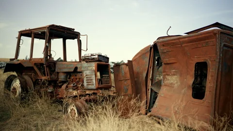 Burned tractor rusts in a junkyard Stock Footage 305310122