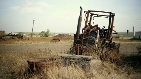 Burned tractor rusts in a junkyard Stock Footage 305311719