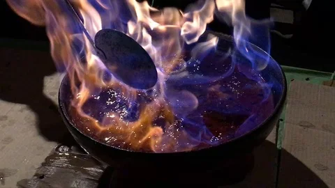 Burning alcoholic beverage with fruit in a bowl  Stock Footage 103564264