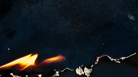 Burning and glowing edge of paper with fire flame and smoke on black background Video stock 306722252