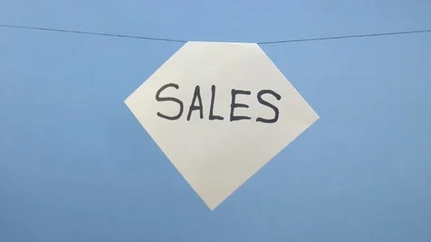 Burning and smoking white sheet of paper with a black inscription "sales" on a Stock Footage 124019272