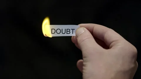 Burning Away Doubt - Hand Setting Fire to Paper note Marked “DOUBT”, Powerful Stock Footage 332495503