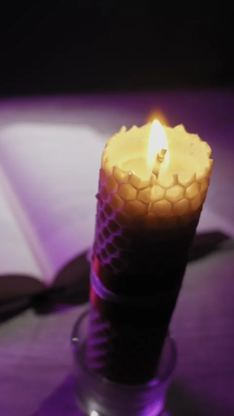 Burning Beeswax Candle With Honeycomb Texture Beside Open Book At Night Stock Footage 330272001