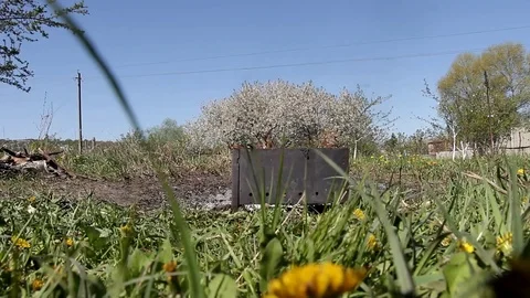 Burning brazier standing in the garden among the blooming trees Stock Footage 101650658
