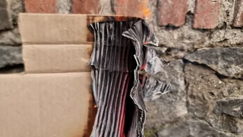 Burning Brown Paper Texture with Real Flames and Charred Edges on Brick Wall Video stock 333579748