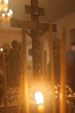 Burning candle on the background of a cross Stock Photos