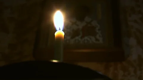 Burning candle on the background of the icon Stock Footage 78910049