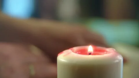 Burning candle. In background man's hands during prayer. Footage HD. Stock Footage 147356908