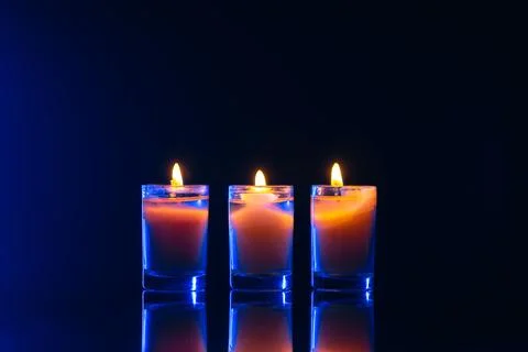 Burning candle on black background with backlight. Memorial Day. Foto stock