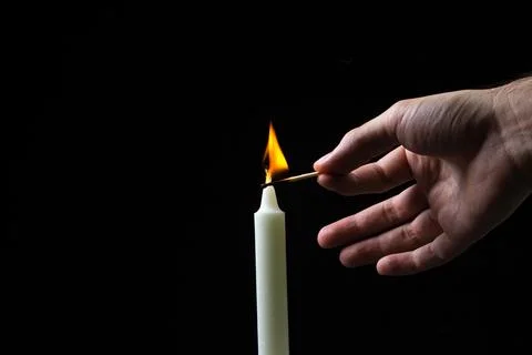 Burning candle on a black background. Fire candles on a dark background.  Stock Photos