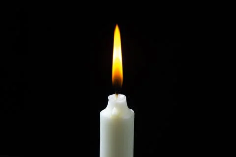 Burning candle on a black background. Fire candles on a dark background. Stock Photos