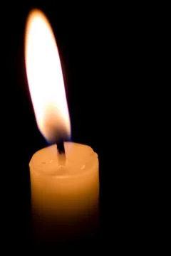 Burning candle on a black background Stock Photos