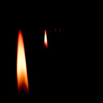 Burning candle on black background Stock Photos