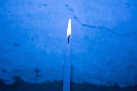 Burning Candle on a blue background 库存照片