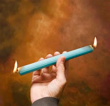 Burning candle at both ends Stock Photos