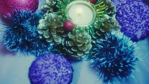 Burning candle in a candlestick on a table, Christmas decorations and chocolate Stock Footage 97585228
