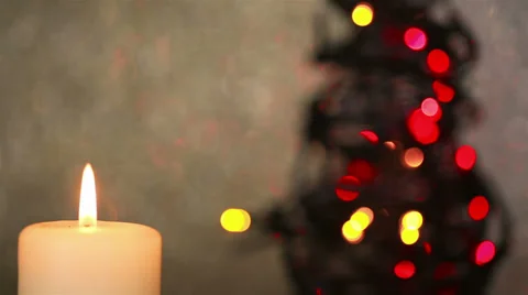 Burning candle with christmas tree in background Video stock 30962395