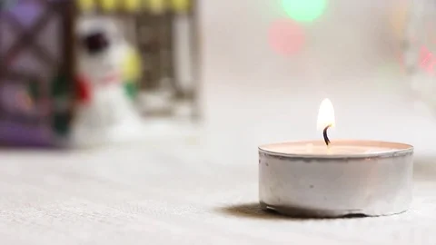 Burning candle close-up against the backdrop of a New Year's house and twinkling Stock Footage 82407470