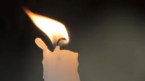 Burning candle on a dark background. The flame sways in the wind Stock Footage 62379146
