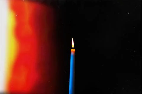 Burning candle on a dark background with light from the lights Stock Photos