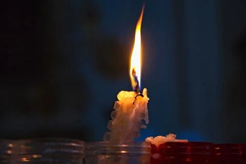 Burning candle on a dark background Stock Photos