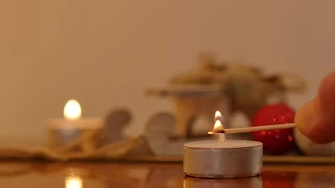 Burning candle in dark. Close up man hand lighting candle with match on black Stock Footage 145709189