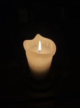 Burning candle on dark surface. Memory day Stock Photos