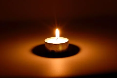 Burning candle in darkness Foto stock