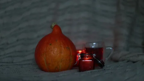 The burning candle is extinguished. Autumn composition:pumpkin, sich, tea, plaid Stock Footage 210221616