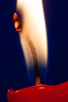 Burning candle flame at blue background Stock Photos