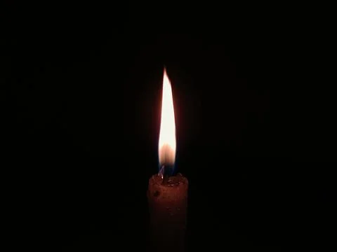 Burning Candle Flame in Darkness Stock Photos