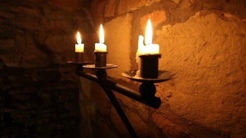 Burning candle holder in medieval cave Stock Footage 72429637