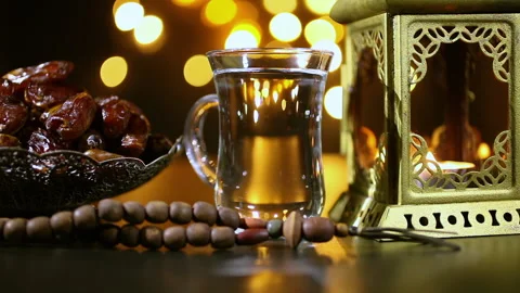 Burning candle in lantern with rosary, dates and cup. Ramadan concept. 库存影片 112704334