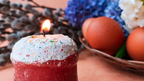 Burning candle made in the shape of Easter cake, eggs, hyacinths and willow Stock Footage 104849685